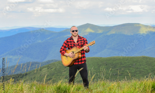 Music for soul. Playing music. Sound of freedom. In unison with nature. Acoustic music. Musician hiker find inspiration in mountains. Keep calm and play guitar. Man with guitar on top of mountain