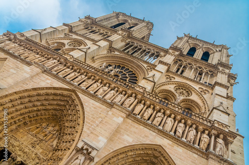 Slanted view of the famous west façade of Notre-Dame cathedral on the Île de la Cité in Paris with a close-up of the Gallery of Kings, a row of 28 statues representing 28 Kings of Judah and Israel.