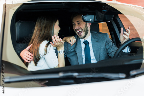 selective focus of excited bearded man looking at woman and gesturing in car © LIGHTFIELD STUDIOS