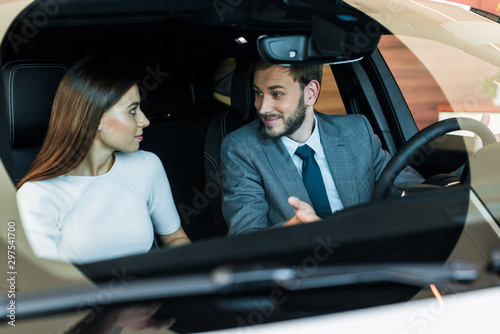 selective focus of bearded man looking at woman in car