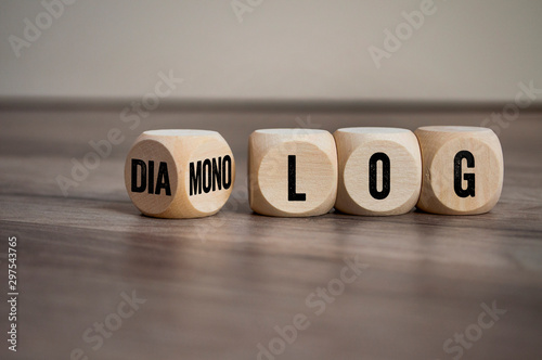 Cubes and dice on wooden background with the german words for dialogue and monologue - dialog und monolog photo