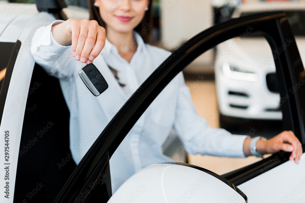 cropped view of happy young woman holding car key cropped view of happy young woman holding car key
