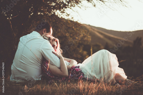 Φωτογραφία Two lovers on a romantic trip see off the sunset on the outdoor.