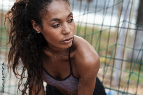 Tableau sur toile Image closeup of african american woman standing by metal fence outdoors