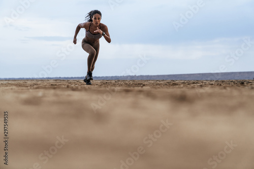Photos Image of serious african american woman in sportswear running by seaside