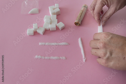 Sugar is a drug. Hand of a woman with sugar imitating cocaine