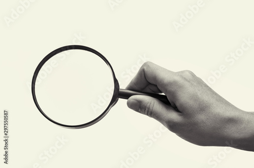 Canvas Print Female hand holding the magnifying glass on isolated background