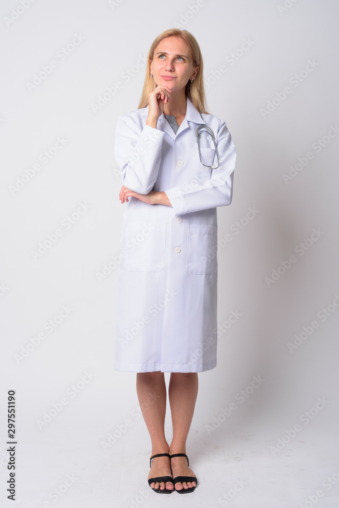Full body shot of young blonde woman doctor thinking Full body shot of young blonde woman doctor thinking