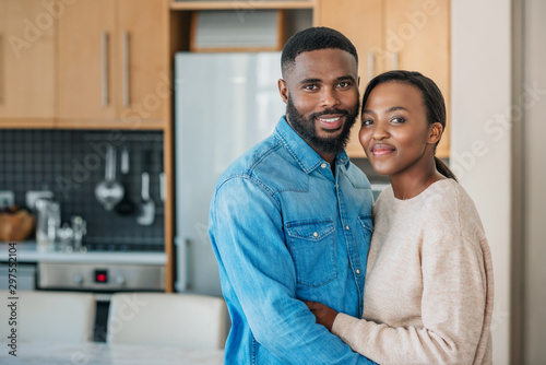 African American couple standing in each other's arms at home