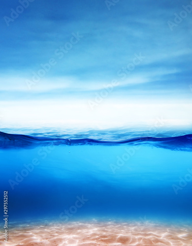 Beautiful underwater sea sandy scene view and ripples on water surface with blue sky and clouds background