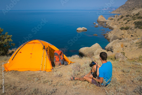 Tourist photographer on the background of the tent and the sea 2