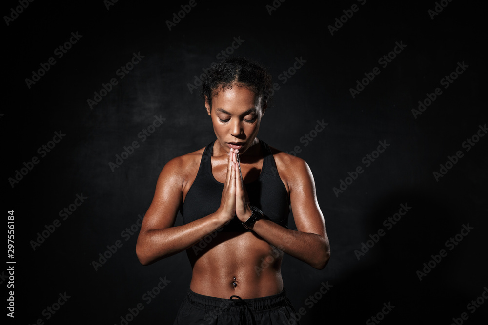 Image of attractive african american woman standing with palms together