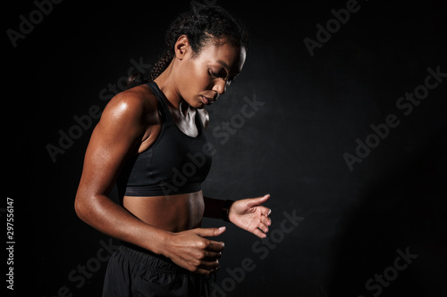 Image of focused african american woman in sportswear doing workout