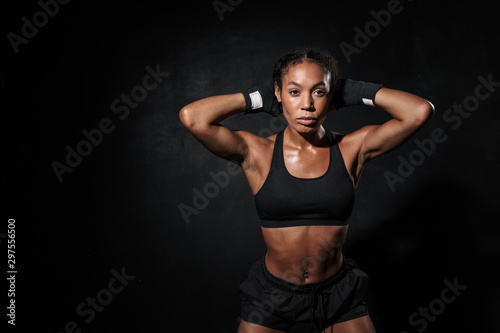 Image of strong african american woman standing in boxing hand wraps