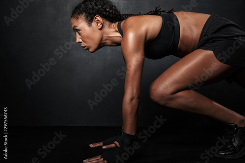Image of muscular african american woman in sportswear doing workout