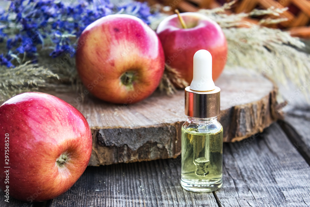 Bottle of apple essential oil and fresh apples on a wooden table. Essential  oil is used to fill lamps, perfumes and in cosmetics. Close-up Stock Photo  - Alamy