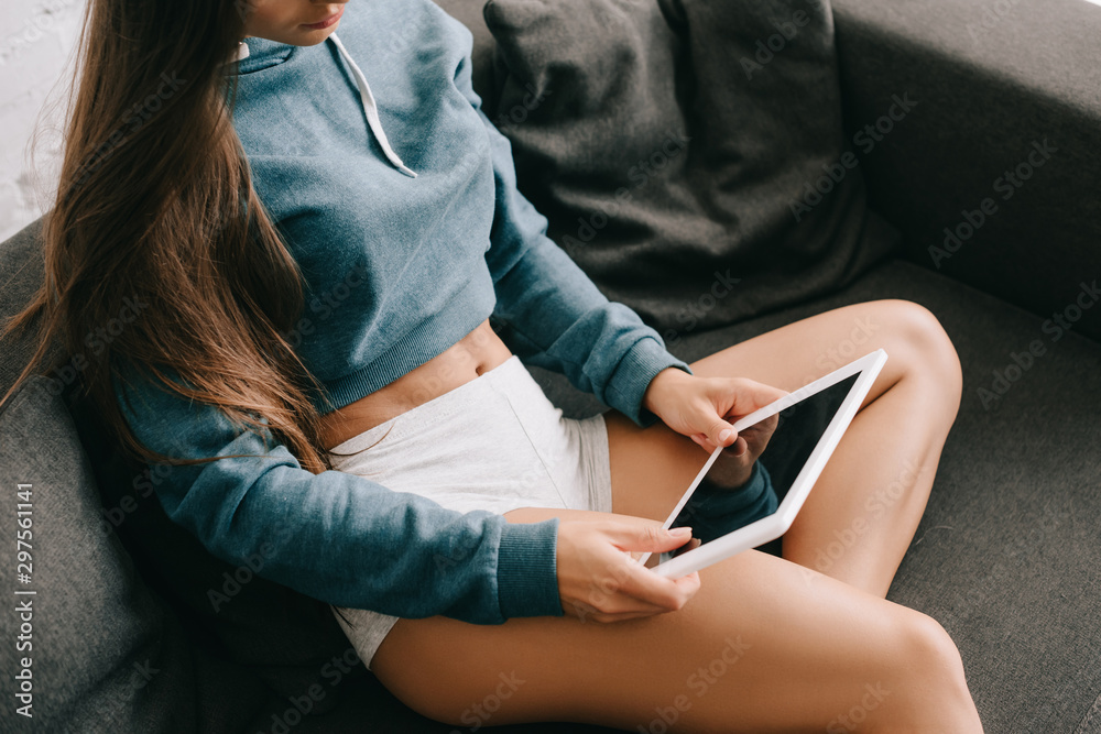 cropped view of girl in panties using digital tablet on sofa