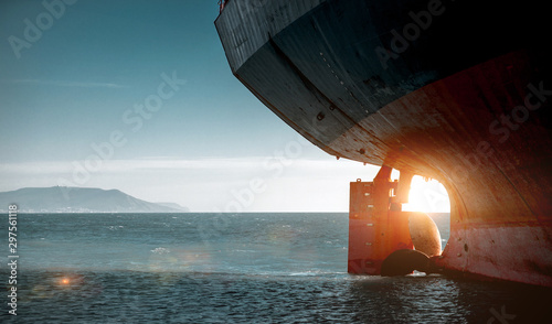 Stern of a cargo ship aground against backdrop of blue sea. World Transport Problems Freight Shipping Concept photo