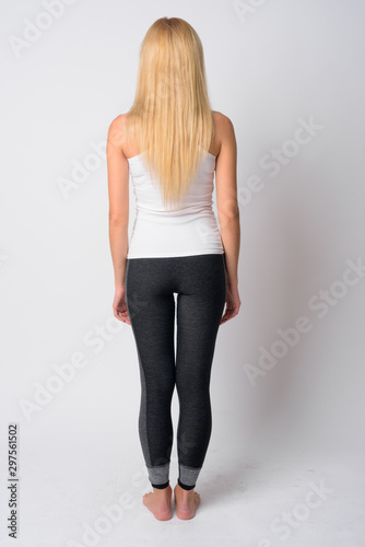 Full body shot rear view of young blonde woman ready for gym