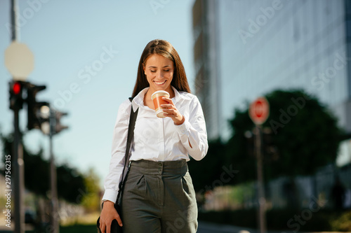 Young businesswoman drinking coffee on the street	