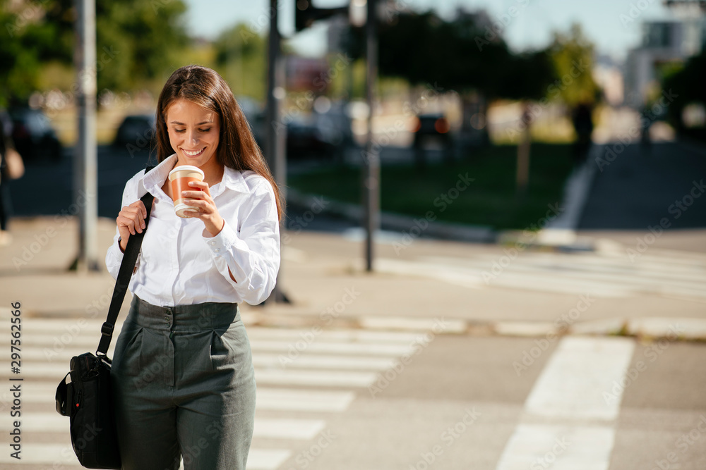 Young businesswoman drinking coffee on the street	