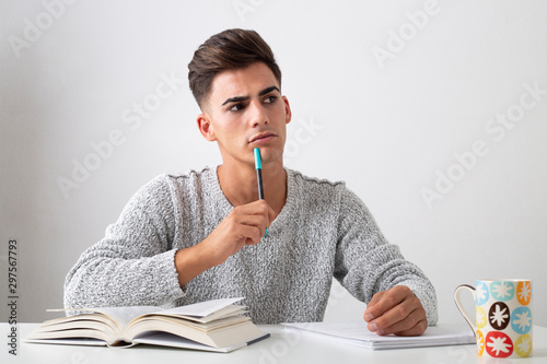 Photos Thoughtful teenager studying on a desk