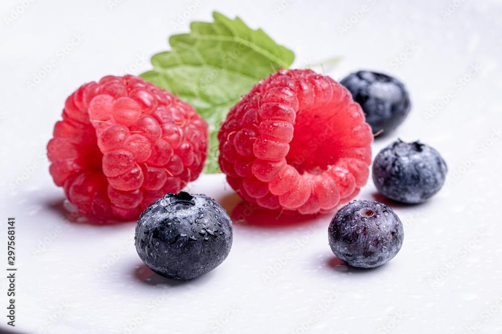 Raspberry with blueberry. Wild berries isolated with leaves on white background. Raspberry with blueberry. Wild berries isolated with leaves on white background.