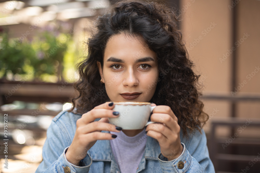 Hot coffee. Beautiful young girl drinking tea or coffee in cafe. Beauty model woman with the cup of hot beverage. There is place for your logo on the cup. Hot coffee. Beautiful young girl drinking tea or coffee in cafe. Beauty model woman with the cup of hot beverage. There is place for your logo on the cup.