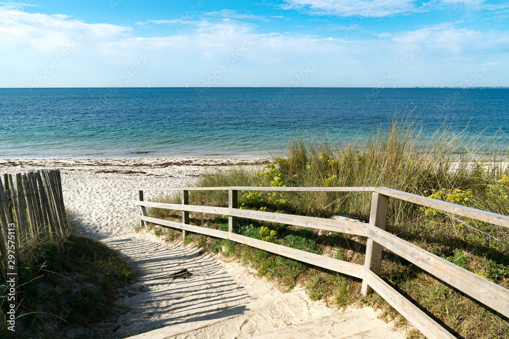 well-kept wooden beach access leading through sand dunes to an empty beach