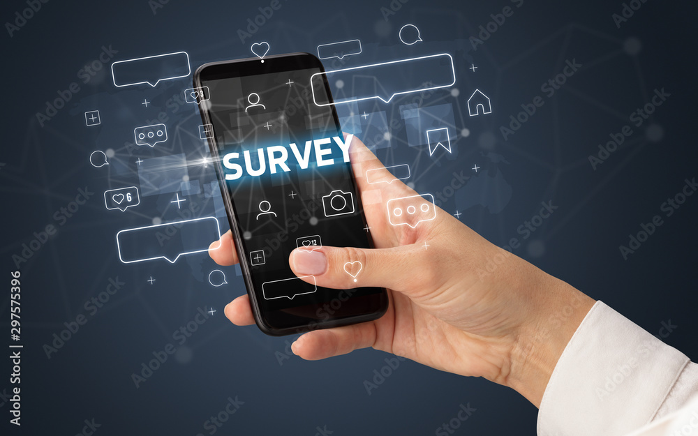 Female hand typing on smartphone with SURVEY inscription, social media concept Female hand typing on smartphone with SURVEY inscription, social media concept