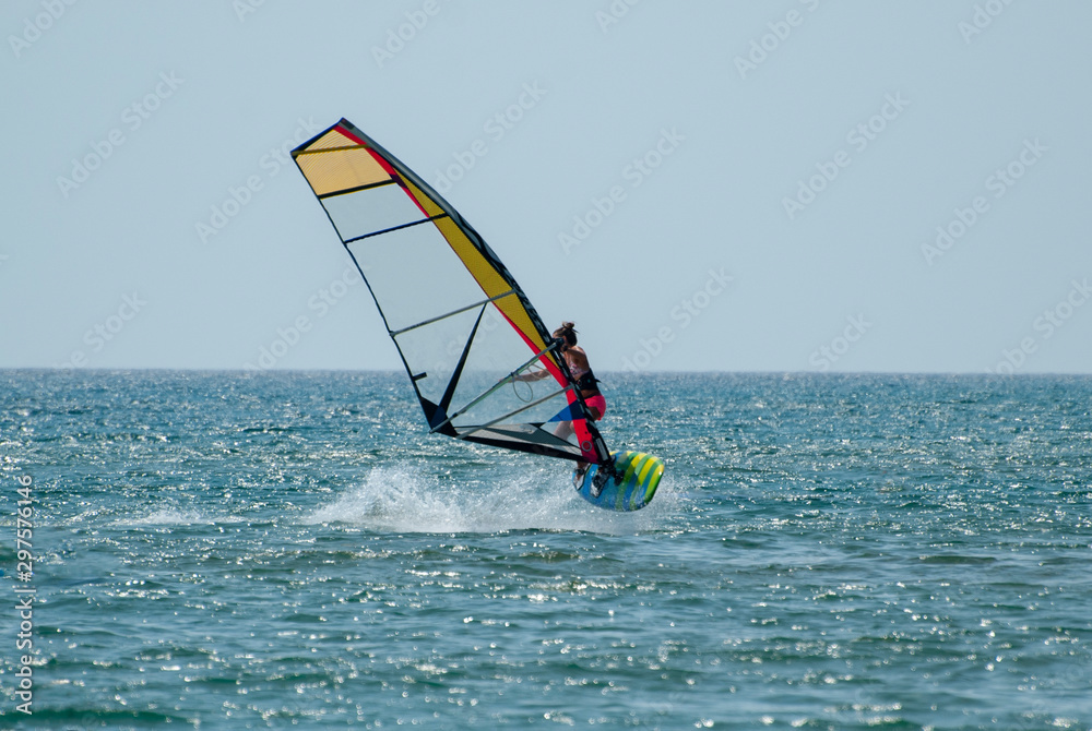 Young girl learns to control a board with a sail