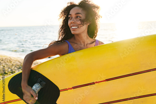 Photography Image of african american woman holding surfboard and smiling