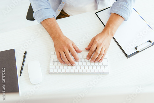 Fotografía top view of broker typing on computer keyboard in office
