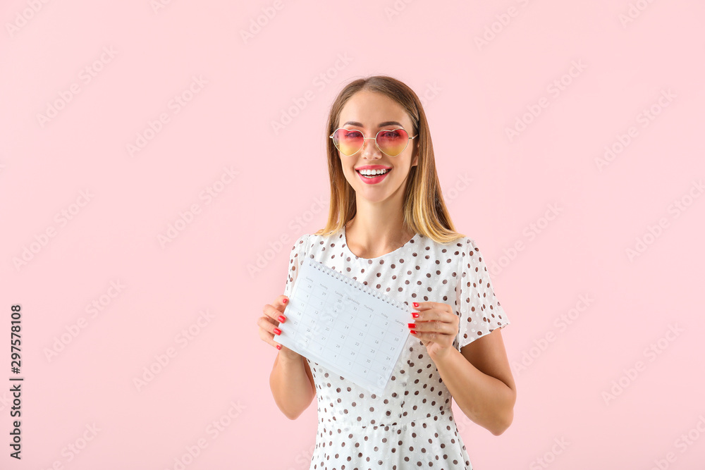Beautiful young woman with calendar on color background. International Women's Day celebration Beautiful young woman with calendar on color background. International Women's Day celebration