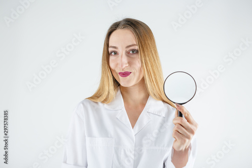 Female doctor with a magnifier in hands