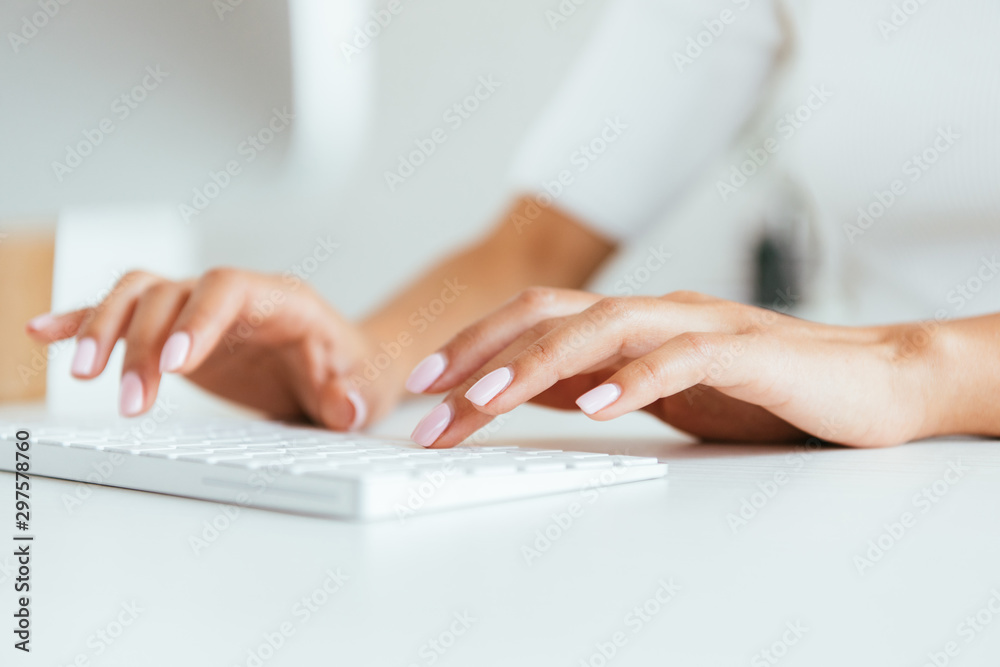 cropped view of broker typing on computer keyboard in office cropped view of broker typing on computer keyboard in office