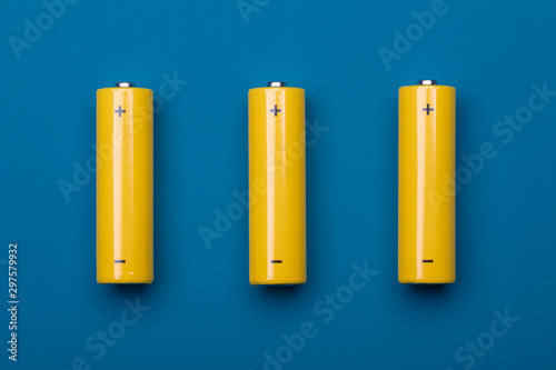 Yellow AA alkaline batteries on blue background photo