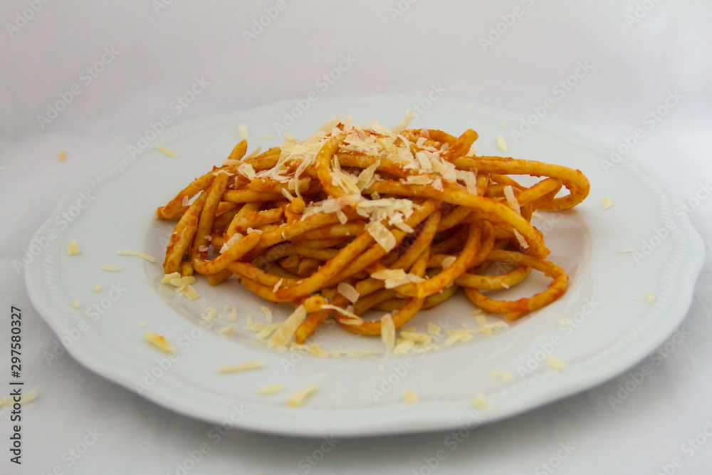 plate of bucatini amatriciana with a drop of pecorino cheese plate of bucatini amatriciana with a drop of pecorino cheese
