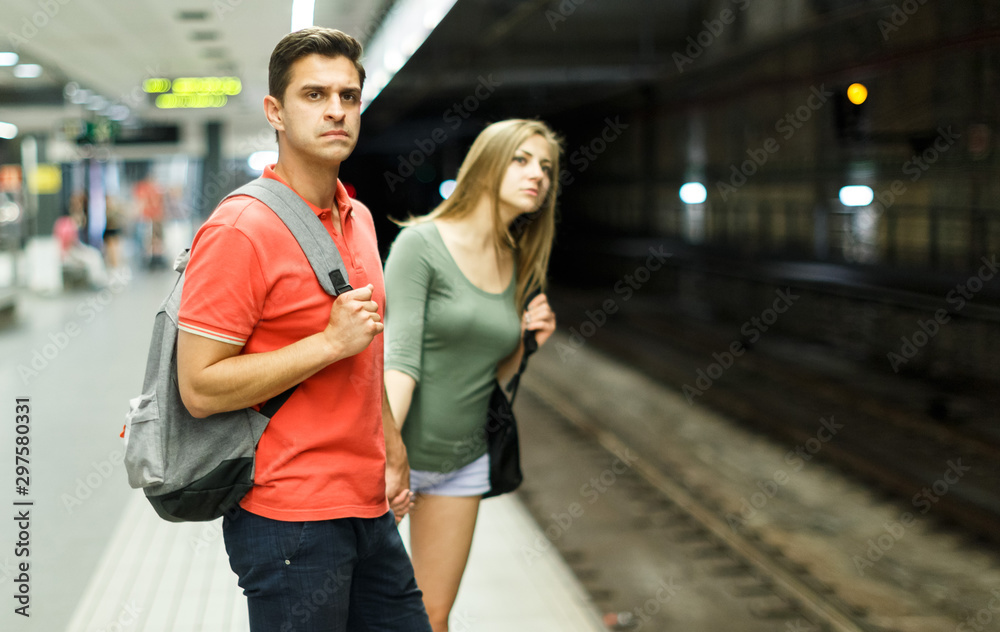 Couple is traveling and waiting train on platform