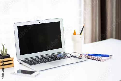 top view of office desk workspace with coffee cup, notebook, smartphone and keyboard on white background with copy space,