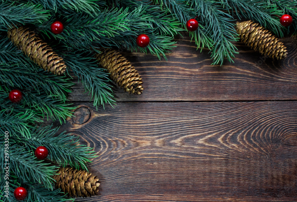 Frame made of fir tree branches and fir cones, red berries, on a wooden brown surface. Frame made of fir tree branches and fir cones, red berries, on a wooden brown surface.