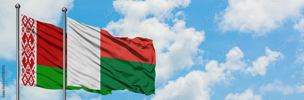 Belarus and Madagascar flag waving in the wind against white cloudy blue sky together. Diplomacy concept, international relations. Belarus and Madagascar flag waving in the wind against white cloudy blue sky together. Diplomacy concept, international relations.