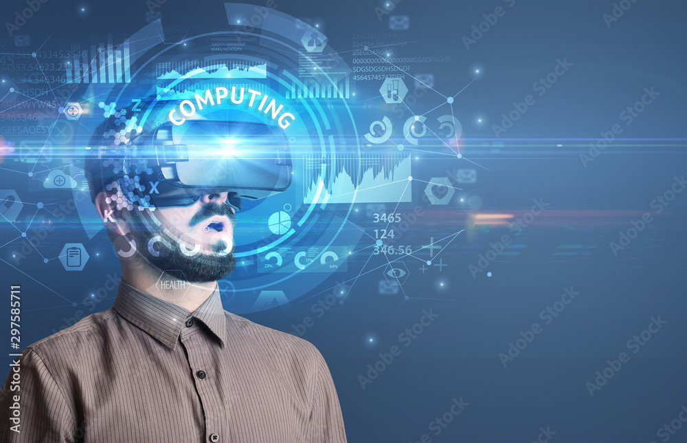 Businessman looking through Virtual Reality glasses with COMPUTING inscription, innovative technology concept Businessman looking through Virtual Reality glasses with COMPUTING inscription, innovative technology concept