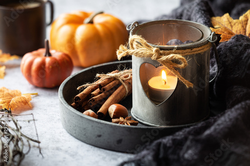 Fototapeta Naklejka Na Ścianę i Meble -  Autumn or fall concept with a romantic shabby chic lantern, aromatic spices, autumnal leaves and pumpkins at the background. Fall home decoration