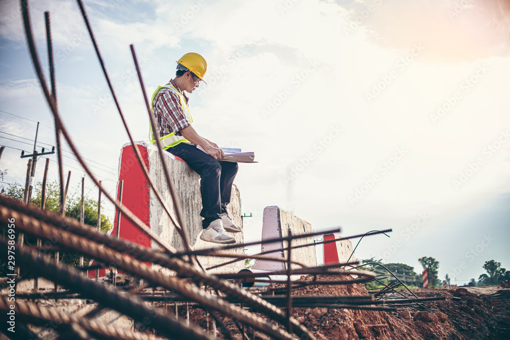 Portrait road Engineer sit down Checking Plans on Barriers To A New Highway Portrait road Engineer sit down Checking Plans on Barriers To A New Highway