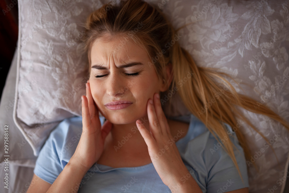 Foto de Jaw pain after waking up or sleeping, TMJ Bruxisum, teeth grinding do Stock Adobe Stock