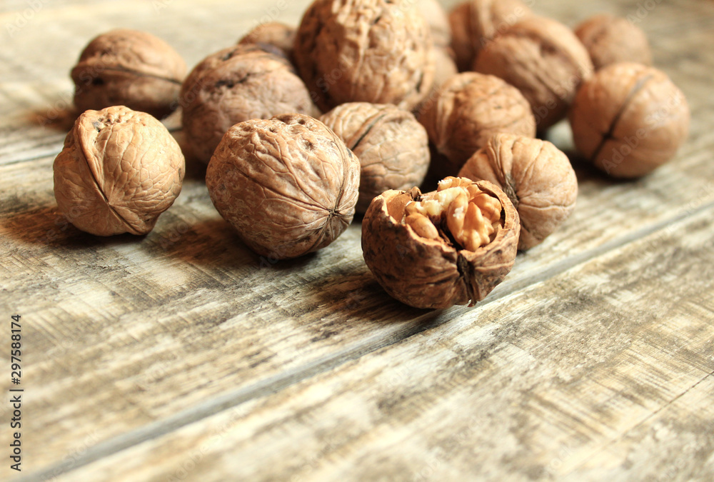 Walnuts lie on a wooden background. One nut is chopped. Walnuts lie on a wooden background. One nut is chopped.