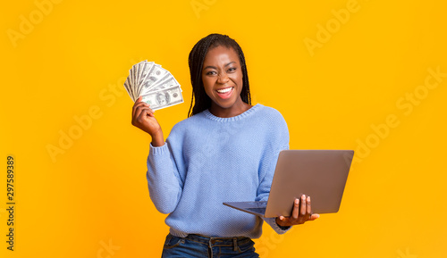 African american young woman making money from internet, using laptop
