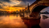 Charles bridge (Karluv most) at sunrise, scenic view of the Old town with Old Town Bridge Tower, colorful sky and historic medieval architecture, Prague, Czech Republic. Holidays in Prague