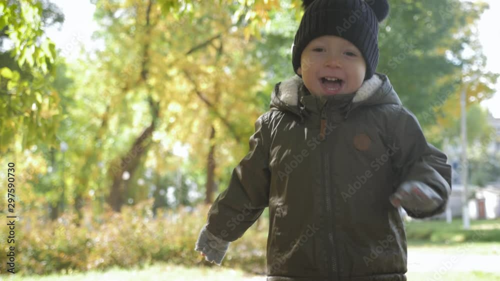 Happy baby boy running in autumnal park. Little child playing on autumn walk. Autumnal forest with golden leaves. Steadicam video, 4K slow motion. Happy baby boy running in autumnal park. Little child playing on autumn walk. Autumnal forest with golden leaves. Steadicam video, 4K slow motion.